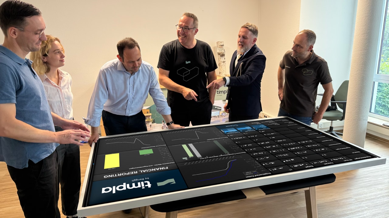 People gathered around a screen showing a DataCards dashboard.